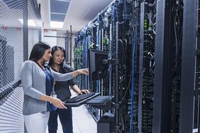 两个女人在服务器室用电脑工作