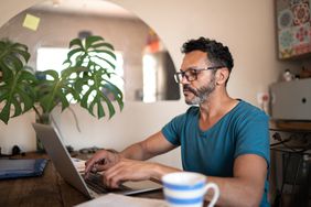 An investor takes a look at stock prices on laptop at home