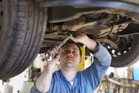 A mechanic works on a car.