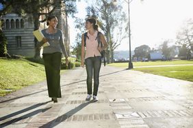 女教授和女学生走在大学校园的小路上