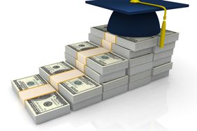 College graduate cap on top of stacks of money