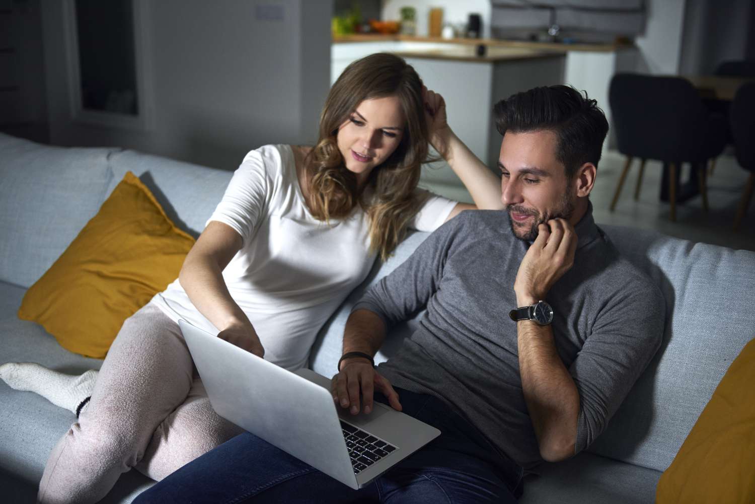 男人和女人坐在沙发上用笔记本电脑工作