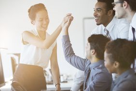 Coworkers cheering in office