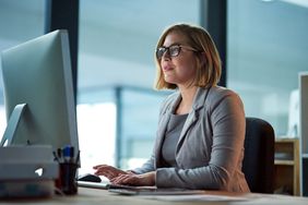 一位女士在办公室里戴着眼镜，盯着桌面电脑屏幕在键盘上打字＂>
          </noscript>
         </div>
        </div>
       </div>
       <div class=