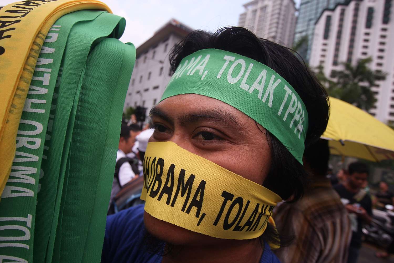一名抗议者戴着大手帕,上面写着“反对奥巴马”抗议期间《泛太平洋战略经济伙伴关系协定(TPPA)在全球创业峰会10月11日,2013年在吉隆坡,马来西亚。”class=