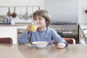 一个小孩在喝一杯果汁。