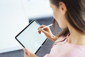 女人用触控笔使用平板电脑