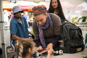 一名白人妇女和她的女儿拿着EBT优惠券(也被称为食品券)购物，她们是美国受益于SNAP的最大种族群体