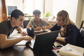 女人在家里给十几岁的男孩看电脑上的信息