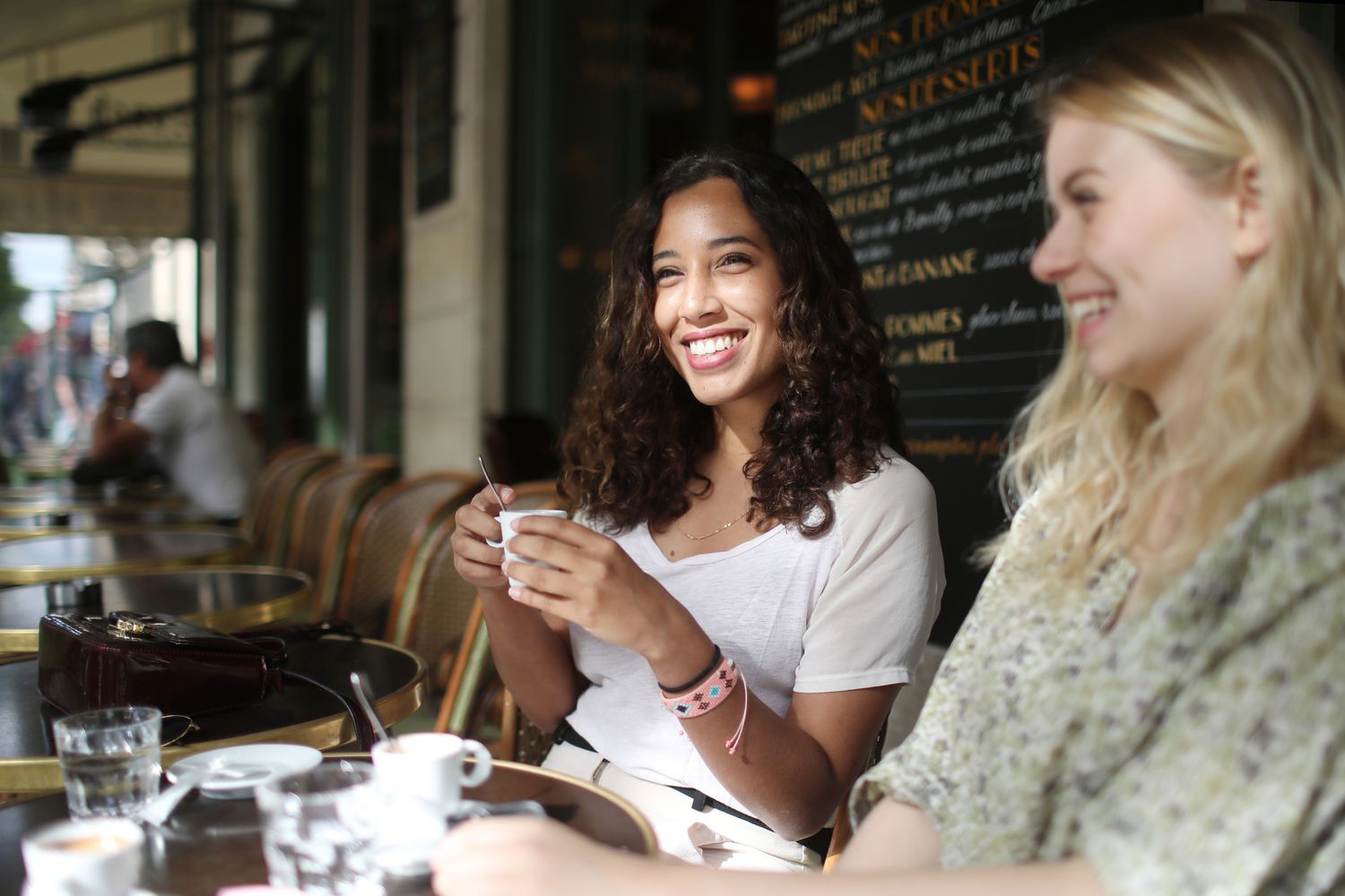 两个年轻女人来到一家巴黎咖啡馆的露台上