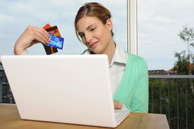 女子在网上购物时手持信用卡
