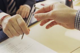 银行家手中笔在桌子一个人申请个人贷款。