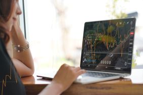 Woman looking at a stock market graph on a laptop screen