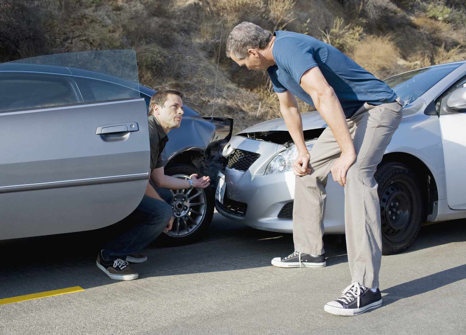 事故中的司机检查损坏情况。