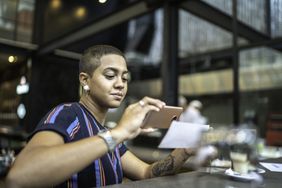 千禧一代女性使用智能手机上的移动银行应用程序存入支票