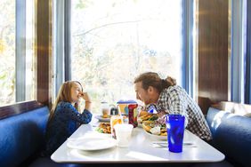 父亲和女儿在一家小餐馆吃午饭。