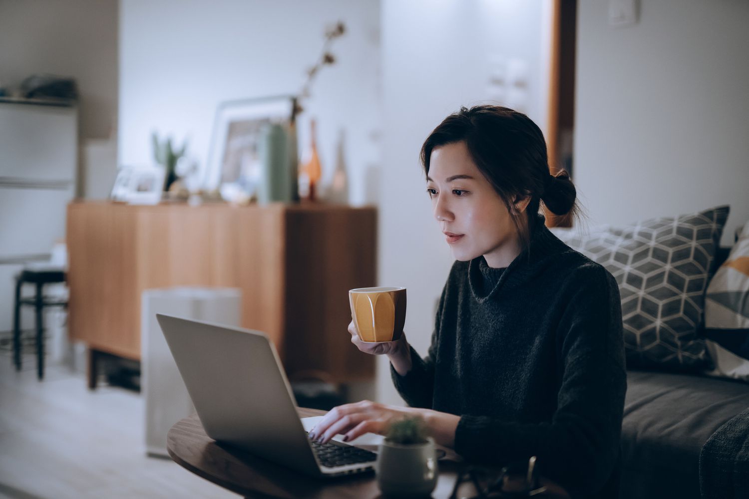 忙碌而专注的年轻亚洲女性在家工作，在笔记本电脑上工作到深夜。家庭办公室，过度工作，截止日期和生活方式的概念
