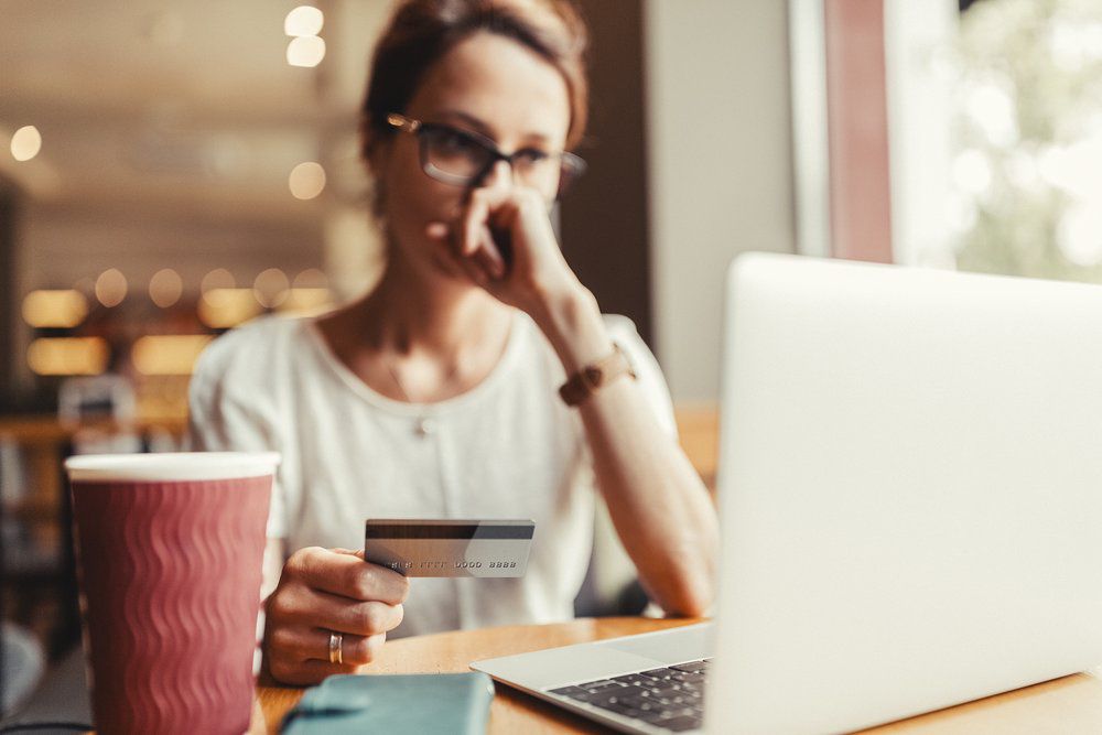 一名女子用笔记本电脑在线支付信用卡账单，但看起来很担心剩余的余额。＂class=