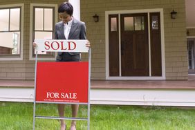 Realtor with sale sign