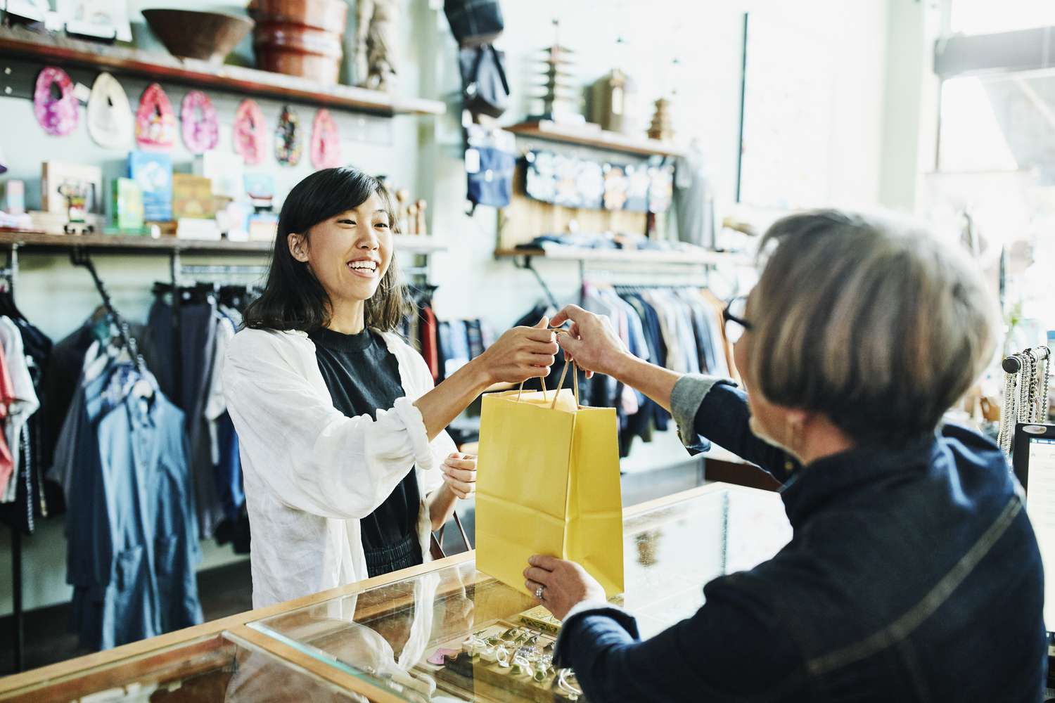 一位女士在她的新社区的一家精品店购买珠宝。