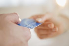 一个人的手给另一个人担保信用卡的特写。