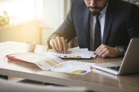 Young businessman showing graphs by pen