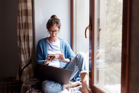 女人在家里靠窗的笔记本电脑和手机上工作＂>
          </noscript>
         </div>
        </div>
       </div>
       <div class=