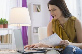 年轻女子在家里用笔记本电脑在线报税。