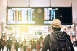 一个背包客走进拥挤的候机楼，深信航空公司信用卡提供的额外优惠可以让他舒适地到达目的地。