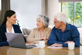 黑发女人身穿蓝色西装解释一些年长的男人和女人坐在她旁边的笔记本电脑。”>
          </noscript>
         </div>
        </div>
       </div>
       <div class=