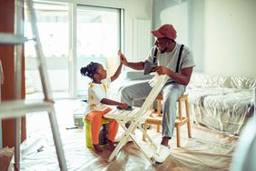 Parent and child sand a chair in a new home.