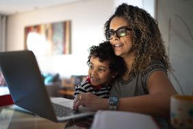 女人在眼镜使用笔记本电脑与年幼的儿子在腿上”>
          </noscript>
         </div>
        </div>
       </div>
       <div class=