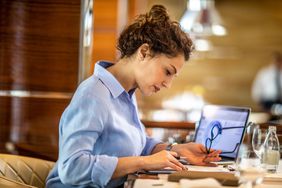 一位女小企业主坐在一家高级餐厅里，从笔记本电脑上的饼图中制作她公司的财务报告＂>
          </noscript>
         </div>
        </div>
       </div>
       <div class=