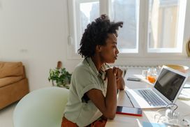 年轻人穿着薄荷衬衫坐在家里用电脑工作