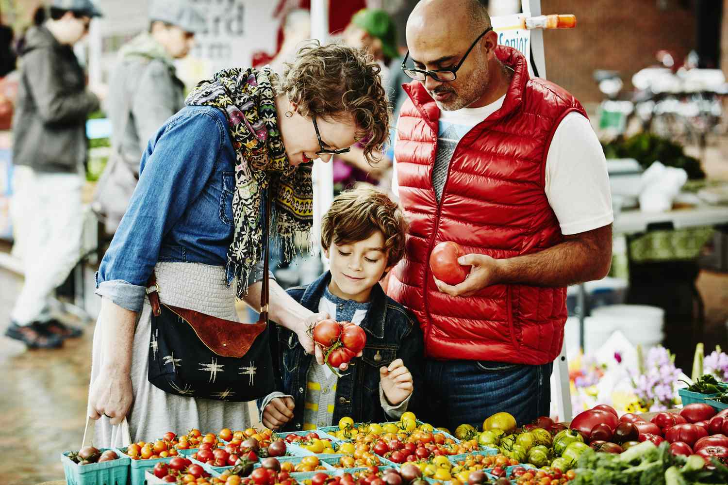 一家人在农贸市场购物时检查西红柿