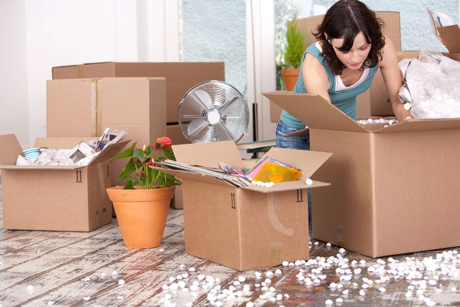 一名妇女在搬迁工作后打开纸箱。