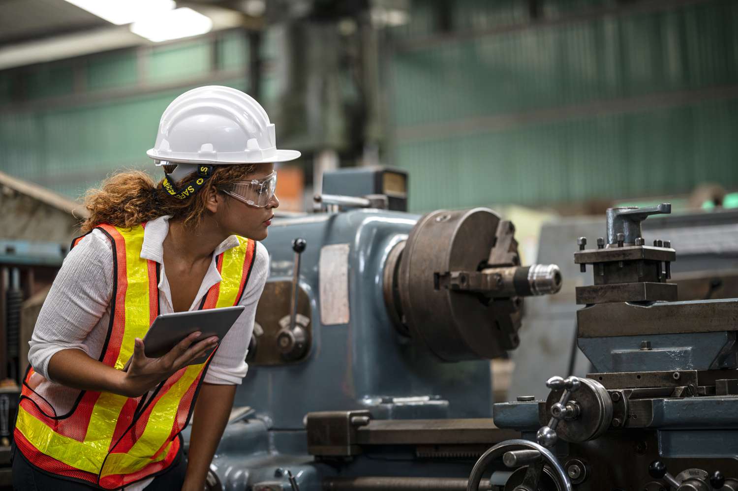 A quality control engineer inspects a machine in a factory.