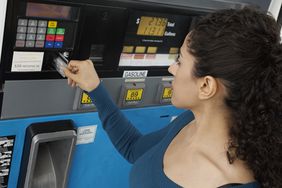 Woman paying with credit card at gas pump