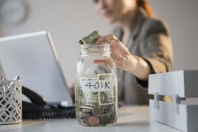 女商人把钱放在办公桌上的401K罐子里