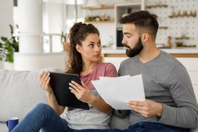 夫妻俩在家里用平板电脑一起查看他们的财务状况