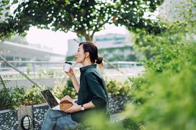 一个女人坐在公园里，用笔记本电脑工作，享受咖啡＂>
          </noscript>
         </div>
        </div>
       </div>
       <div class=