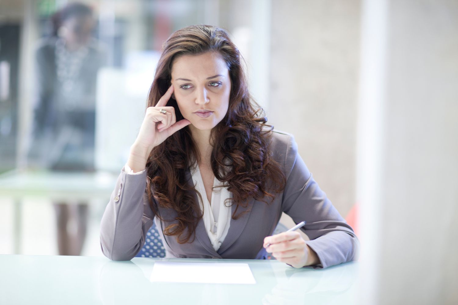 一位女士坐在办公桌前，想知道她是否能胜任目前的工作——或者是时候辞职了。