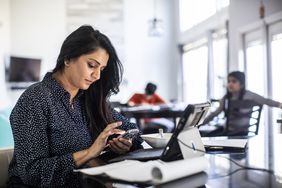 一个女人坐在她的餐桌和视图信用局信息她的手机和电脑”>
          </noscript>
         </div>
        </div>
       </div>
       <div class=