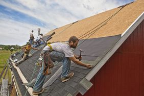 在建筑物上安装新屋顶的一队工人。