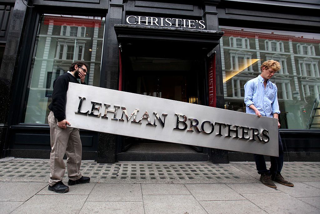 佳士得拍卖行(Christie’s auction house)的两名男性员工操纵雷曼兄弟(Lehman Brothers)公司标志，为清算该公司资产做准备。