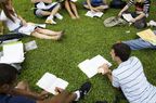 一群大学生在外面的草地上学习