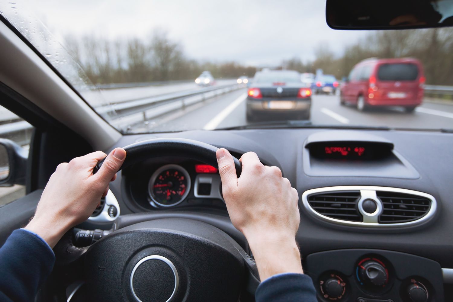 特写一个人的手在方向盘上的一辆汽车行驶在高速公路上的业务。