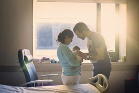 两个人在病房里抱着一个婴儿。