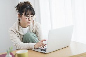 戴眼镜的女人在笔记本电脑上工作