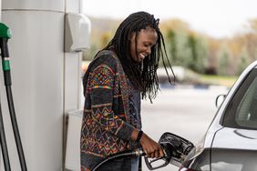 一名女子在加油站给她的车加油。